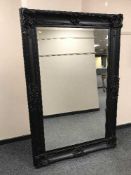 A large black ornate framed bevelled mirror 121 cm x 181 cm