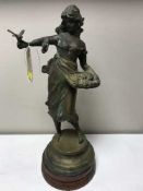 A spelter figure a lady with a bird on a metal base