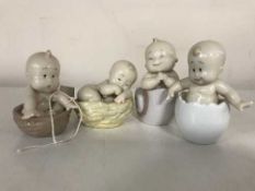 Four Nao figures of babies seated in basket, shell,