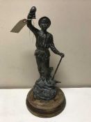 A bronze figure of a miner on a wooden base