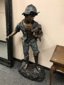 A patinated bronze statue depicting a boy holding a fish, height 140 cm.