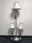 A contemporary floor lamp with shade together with a pair of matching table lamps