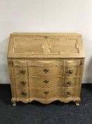An early 20th century oak serpentine fronted bureau