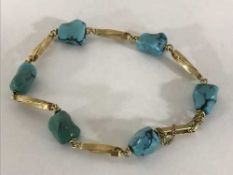 A gold and turquoise bracelet
