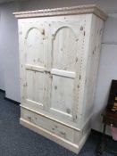 A light pine double door wardrobe fitted with a drawer,