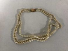 A triple strand pearl necklace with 9ct gold clasp