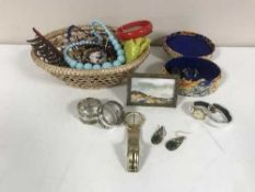 A basket of costume jewellery, plated napkin rings,