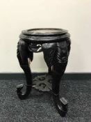 An oriental hardwood plant stand with rouge marble top on elephant trunk legs,