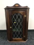 An inlaid mahogany hanging corner cabinet with leaded glass doors