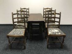 An oak drop leaf table and six oak ladder back chairs