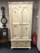 A light pine double door wardrobe fitted with a drawer,