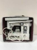A cased Jamone electric sewing machine