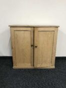 A stripped pine double door cabinet