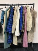 A rail containing two lady's hand bags and a quantity of lady's coats, kilt,