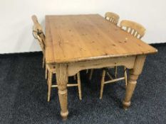 A rectangular pine kitchen table and four chairs