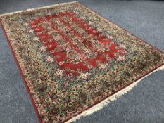 A large Persian carpet on red ground,