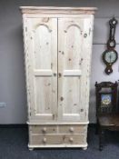 A light pine double door wardrobe fitted with a drawer,