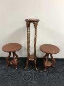 A mahogany barley twist plant stand together with a pair of circular lamp tables