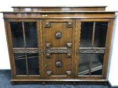 An Edwardian carved oak triple door bookcase