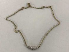 A gold necklace set with five diamonds