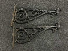 A pair of ornate cast metal wall brackets