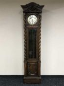 A carved oak cased grandfather clock with barley twist supports, silvered dial,