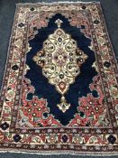 A fringed Persian woollen rug on blue ground