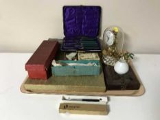 A tray containing anniversary clock under dome, several boxes of plated cutlery,