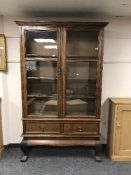 An Edwardian oak glazed bookcase fitted with two drawers