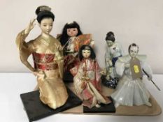 Four Japanese geisha figures and a figure of a Samurai