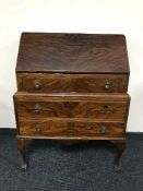 A walnut bureau on claw and ball feet