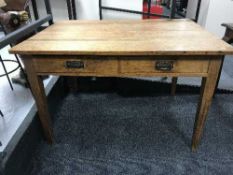 An oak writing table fitted two drawers