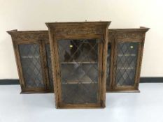 Three carved oak leaded glass cabinets