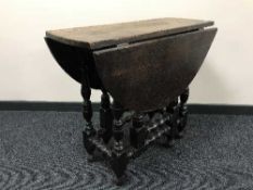 An antique oak drop leaf table