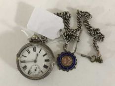 A silver open faced key wound pocket watch on silver Albert chain with suspended token