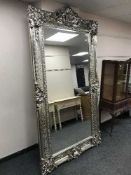 A large and ornate 7ft by 3ft silvered mirror