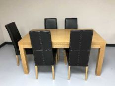 A contemporary oak dining table and five leather chairs