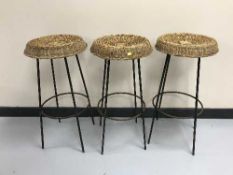 A set of three wicker seater bar stools