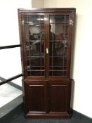 A mahogany double door glazed corner cabinet fitted cupboards below,