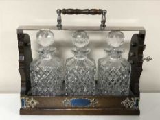 A Victorian style three decanter Tantalus with silver plated mounts