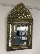 An ornate cushion framed mirror