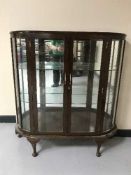 A walnut bow-fronted display cabinet