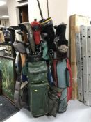 Three golf bags and a large quantity of clubs and a fishing rod