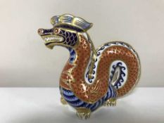 A Royal Crown Derby paperweight modelled as a dragon with gold coloured stopper