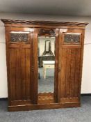 An Edwardian mahogany triple door mirrored wardrobe