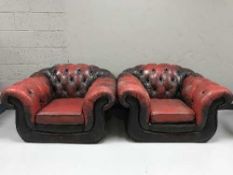 A pair of Chesterfield style button backed red leather armchairs