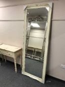 A tall rectangular cream framed mirror