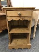 A pine bedside stand fitted a drawer
