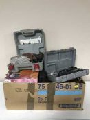 A box containing boxed Dremel set, boxed detail sander,