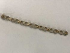 An 18ct gold diamond set bracelet, the seven principal stones each weighing approximately 0.